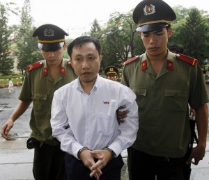 Dissident Nguyen Bac Truyen (C) is led t